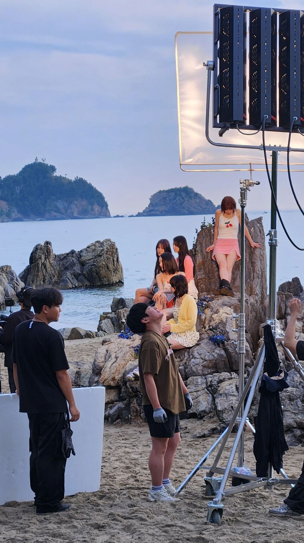 StageKnot production crew filming a fashion shoot on a rocky beach in Korea