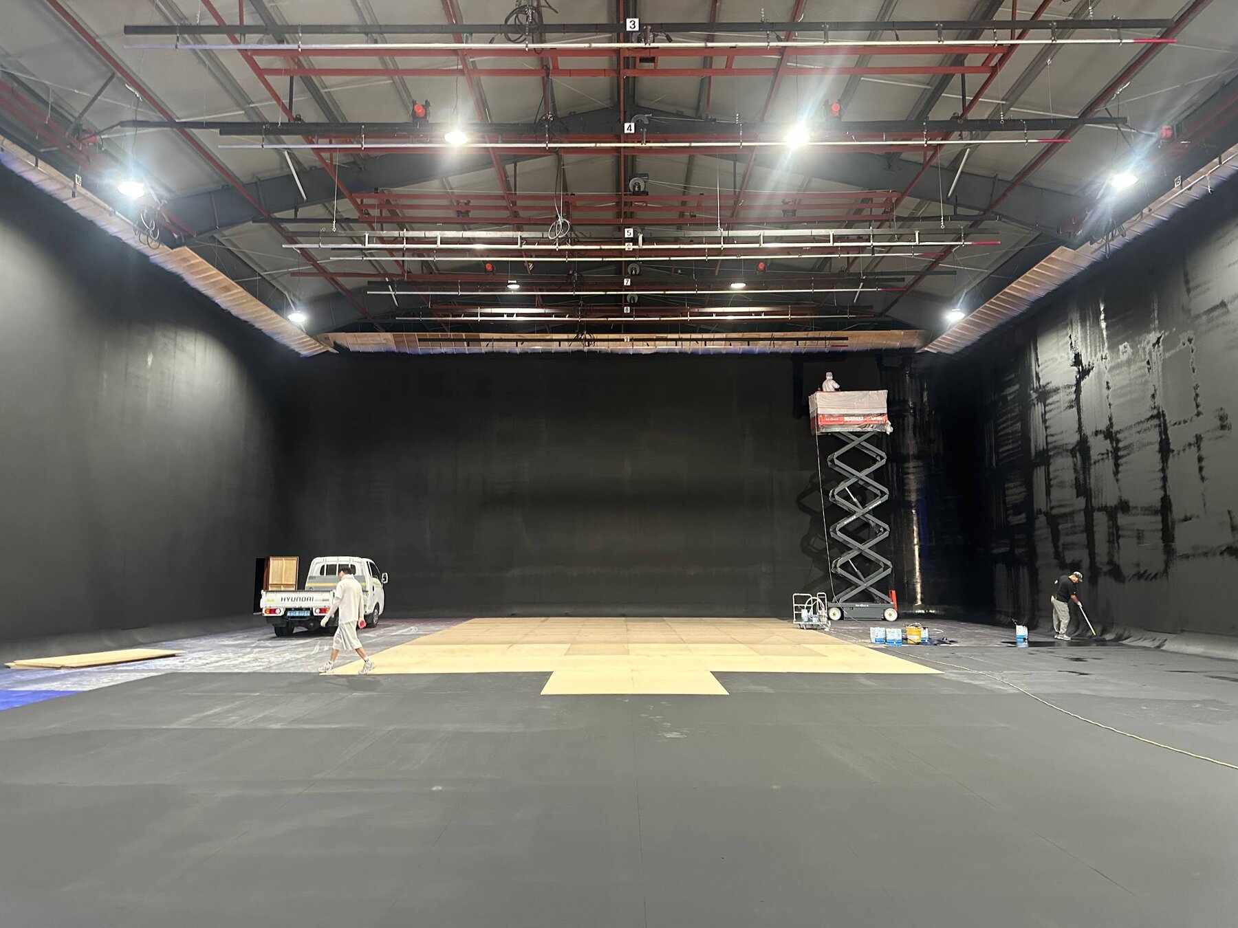 Empty black-painted soundstage shell with floor marked out for the set