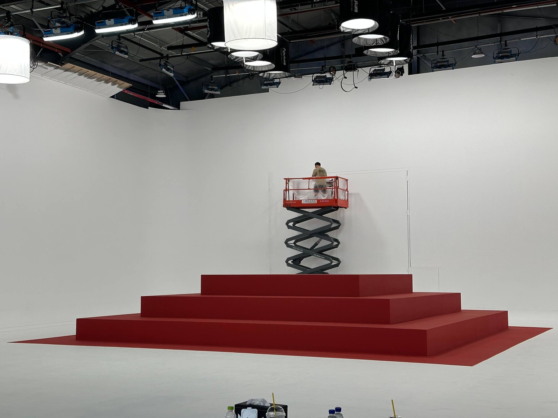 Crew on a scissor lift finishing the red paint on a stair pyramid set