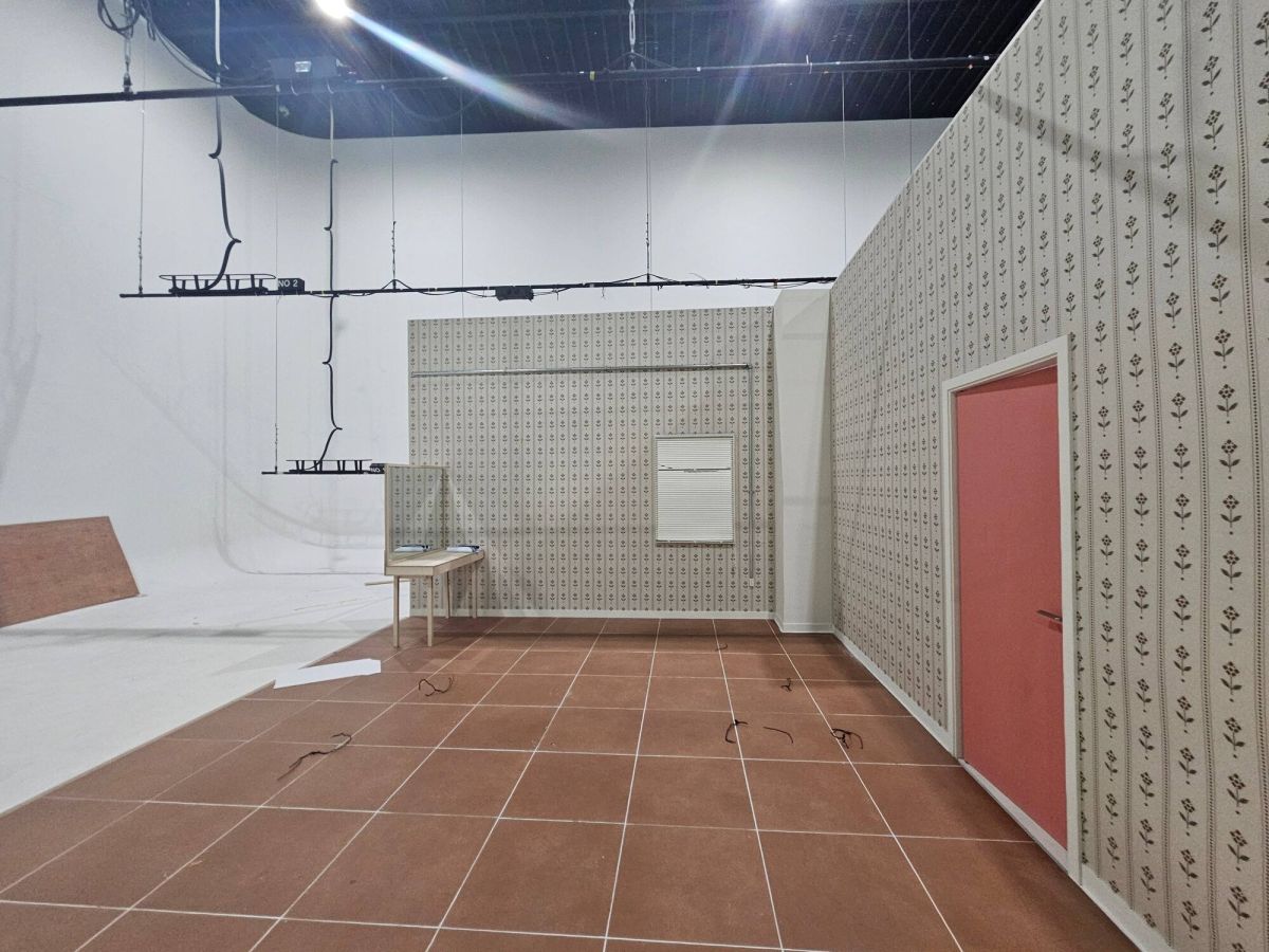 Retro Korean apartment-style set built inside a StageKnot soundstage, with floral wallpaper, terracotta tile floor and a pink door